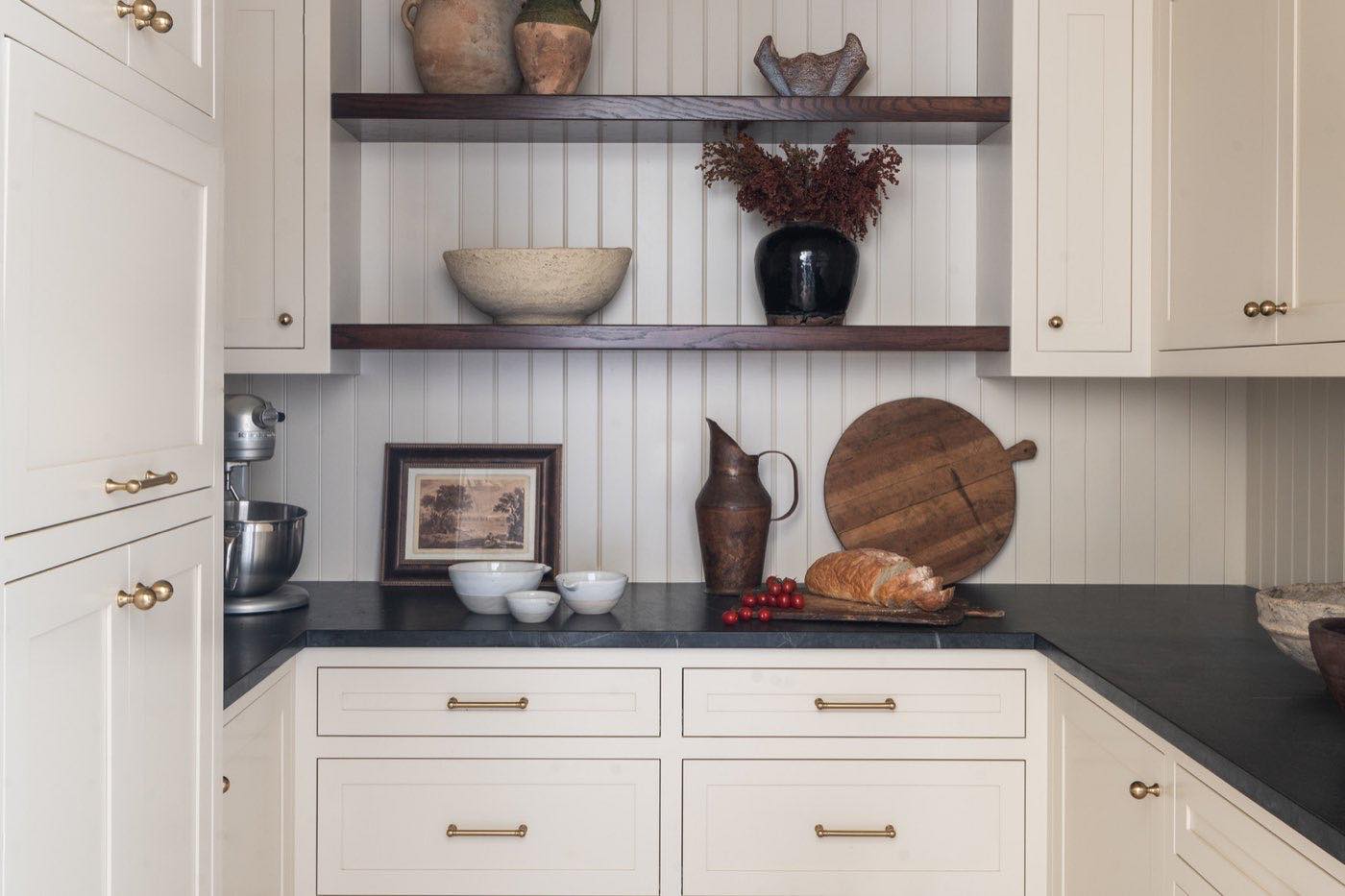 Butler's pantry with cream inset cabinetry, soapstone counters and open walnut shelving